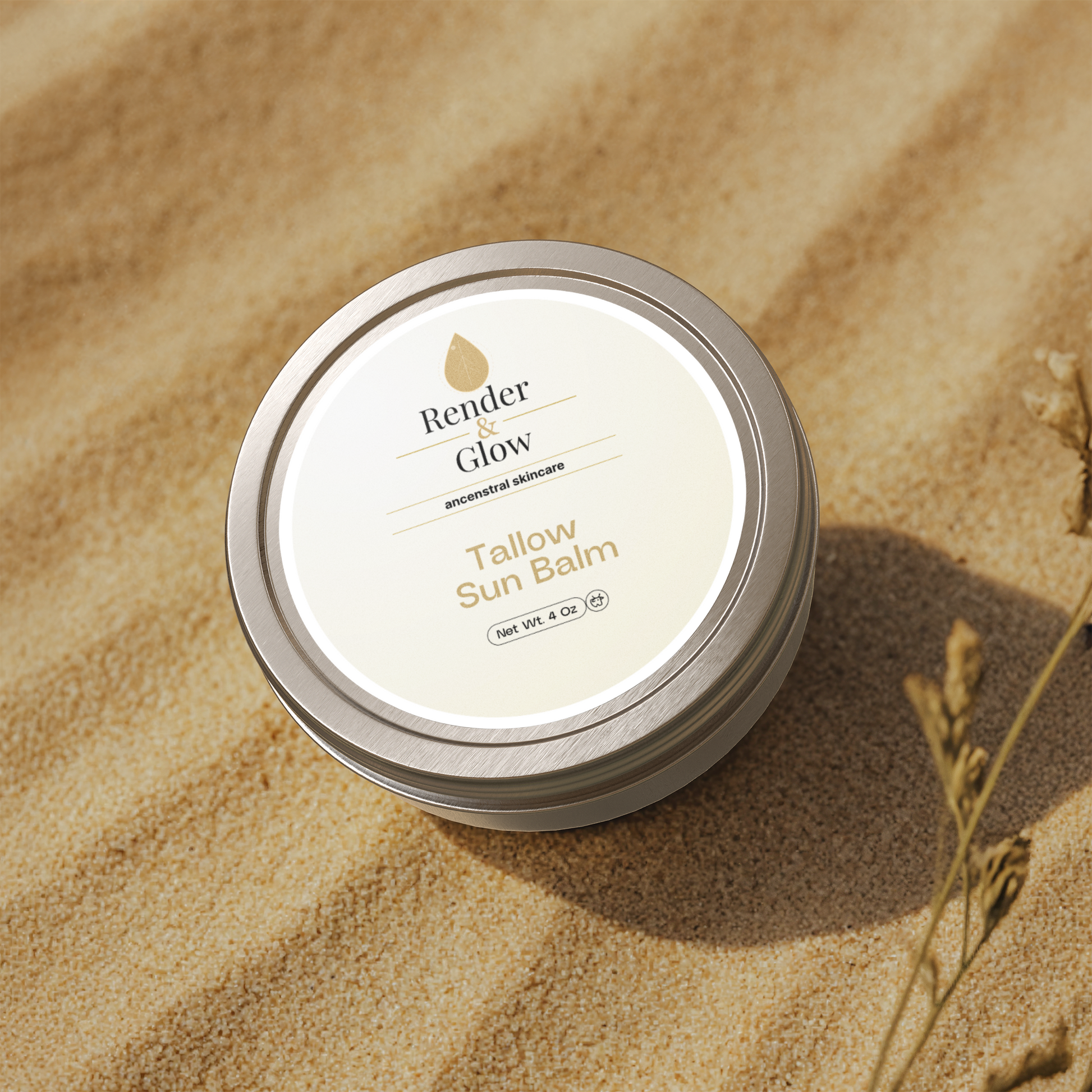 Render & Glow’s Tallow Sun Balm sits on sand with dried grass—a natural choice for sunny-day sun protection.